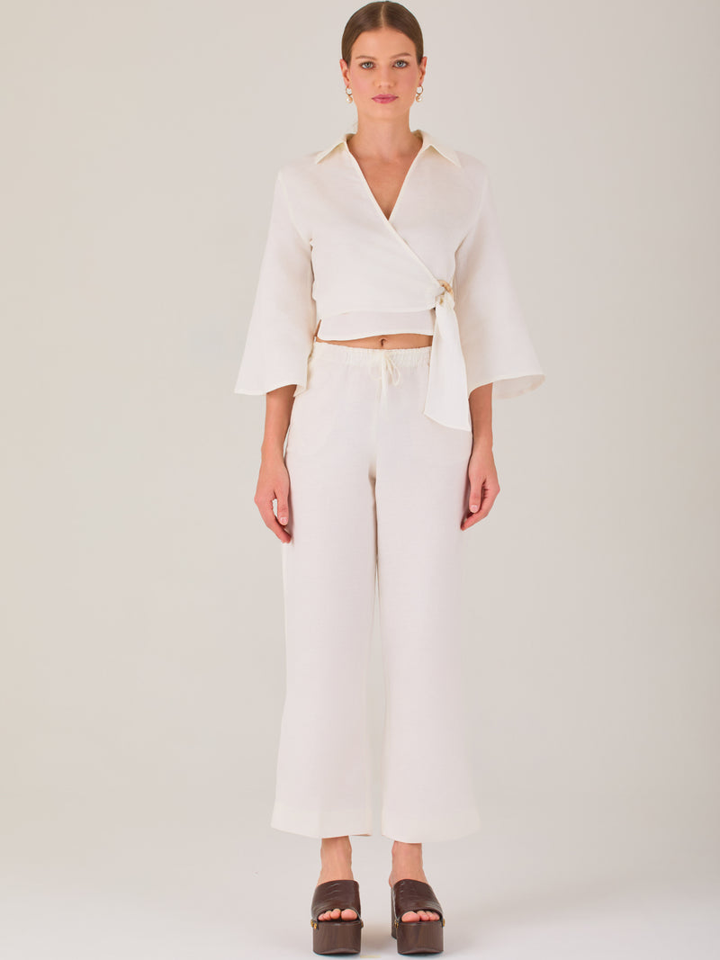 Pantalón blanco de tiro alto con pretina elástica y cordón ajustable. Corte recto y relajado, ideal para un look cómodo y fresco