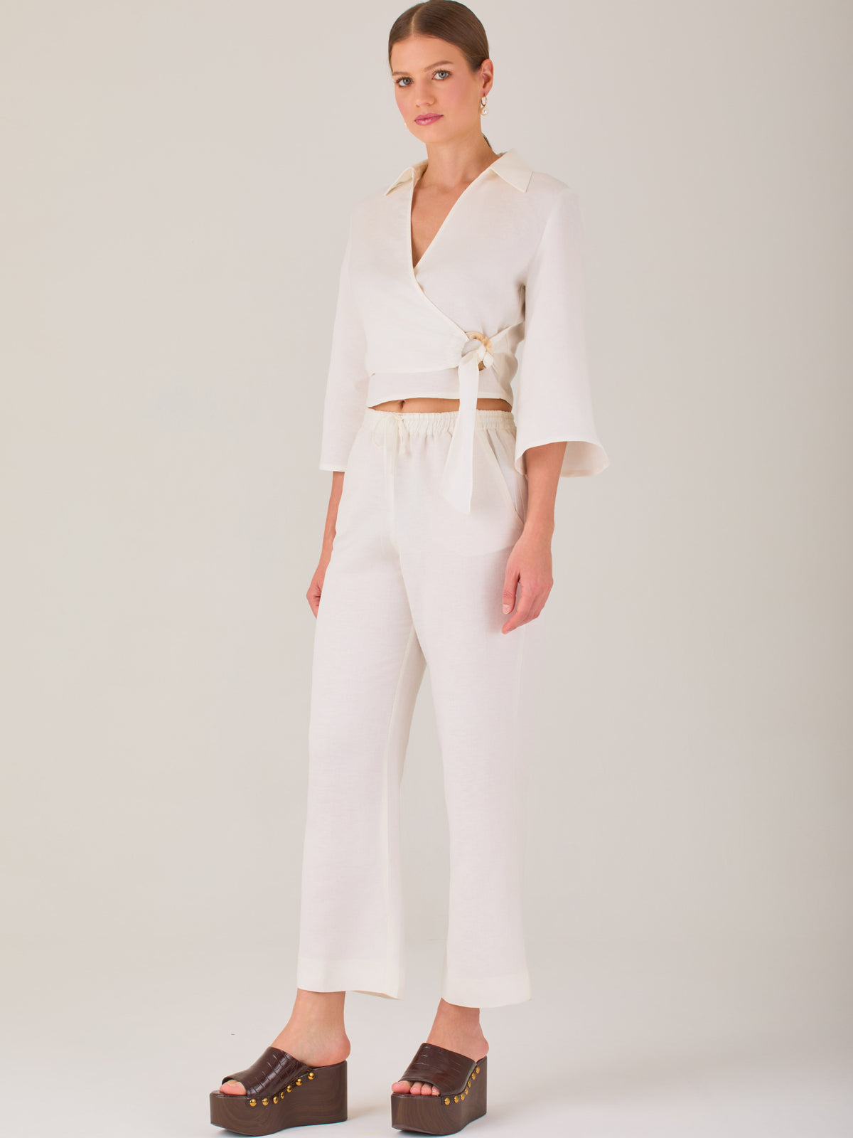 Pantalón blanco de tiro alto con pretina elástica y cordón ajustable. Corte recto y relajado, ideal para un look cómodo y fresco