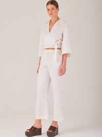Pantalón blanco de tiro alto con pretina elástica y cordón ajustable. Corte recto y relajado, ideal para un look cómodo y fresco