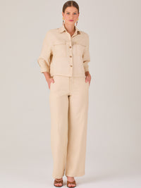 Este pantalón tiene un diseño sofisticado y moderno, confeccionado en un tono beige claro muy versátil. Presenta una silueta de pierna recta y ligeramente amplia, lo que aporta una caída elegante y cómoda. La cintura es de talle medio-alto, con cierre delantero oculto y detalles de pinzas que estilizan la figura. Incluye trabillas para cinturón y bolsillos laterales funcionales, además de costuras marcadas al frente que aportan estructura. Es una prenda ideal para looks de oficina, conjuntos monocromáticos 