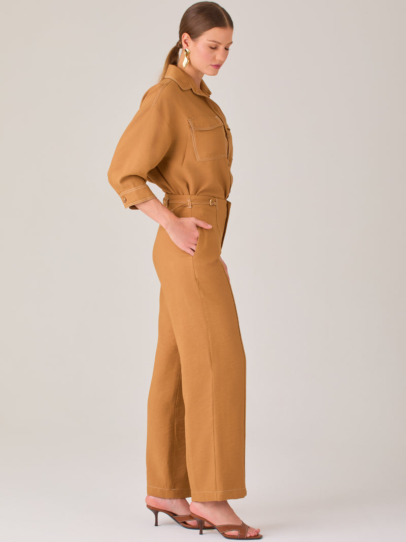 Este pantalón tiene un diseño sofisticado y moderno, confeccionado en un tono beige claro muy versátil. Presenta una silueta de pierna recta y ligeramente amplia, lo que aporta una caída elegante y cómoda. La cintura es de talle medio-alto, con cierre delantero oculto y detalles de pinzas que estilizan la figura. Incluye trabillas para cinturón y bolsillos laterales funcionales, además de costuras marcadas al frente que aportan estructura. Es una prenda ideal para looks de oficina, conjuntos monocromáticos 