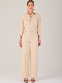 Este pantalón tiene un diseño sofisticado y moderno, confeccionado en un tono beige claro muy versátil. Presenta una silueta de pierna recta y ligeramente amplia, lo que aporta una caída elegante y cómoda. La cintura es de talle medio-alto, con cierre delantero oculto y detalles de pinzas que estilizan la figura. Incluye trabillas para cinturón y bolsillos laterales funcionales, además de costuras marcadas al frente que aportan estructura. Es una prenda ideal para looks de oficina, conjuntos monocromáticos 