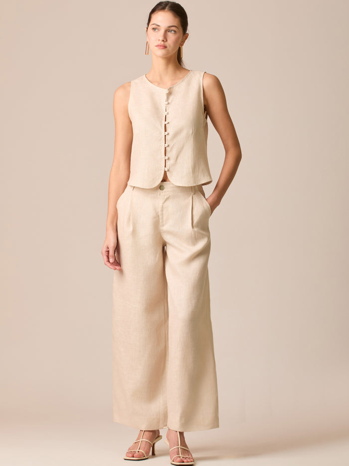 Pantalón de tiro medio con pretina plana, pinzas frontales y corte recto amplio hasta el tobillo, confeccionado en un tejido liviano de textura natural que aporta un look sofisticado y relajado