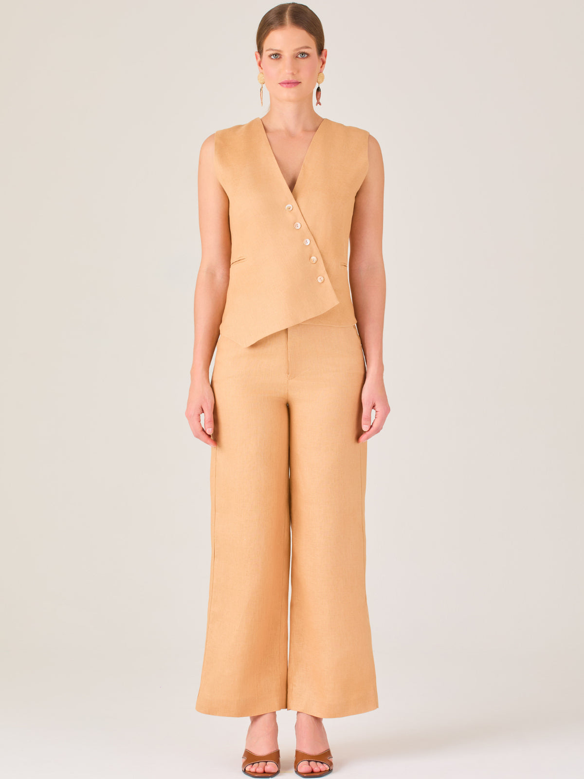 Minimalista y sofisticado, este pantalón de silueta recta y tiro alto ofrece una caída ligera y pulida. Confeccionado en una tela fresca y estructurada, es ideal para climas cálidos y looks versátiles. Perfecto para combinar con tops entallados o prendas sastre, ya sea en entornos profesionales o estilismos casuales con elegancia atemporal.
