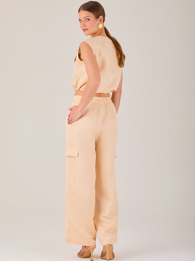 Este pantalón de corte recto y silueta ancha tiene un diseño tipo cargo, con bolsillos de solapa a los costados de las piernas que aportan un toque utilitario. La pretina combina funcionalidad y estilo: es parcialmente elástica en la parte posterior para mayor comodidad, mientras que el frente incluye cierre con botón y pinzas que añaden estructura. Su diseño equilibra lo casual y lo sofisticado, ideal para looks versátiles.