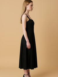 Vestido midi con tirantes anchos y escote recto que enmarca los hombros con elegancia. El cuerpo entallado lleva cortes verticales tipo corsé que definen la silueta, mientras la falda evasé abre con amplitud y movimiento hasta media pantorrilla. Un diseño depurado y femenino, ideal para eventos o noches especiales; combínalo con sandalias de tacón y joyería mínima para un look impecable