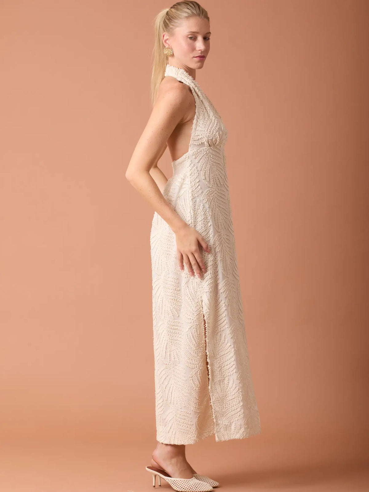 Vestido largo beige con escote halter y diseño texturizado elegante ideal para eventos especiales.