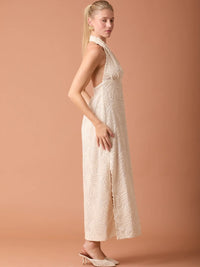 Vestido largo beige con escote halter y diseño texturizado elegante ideal para eventos especiales.