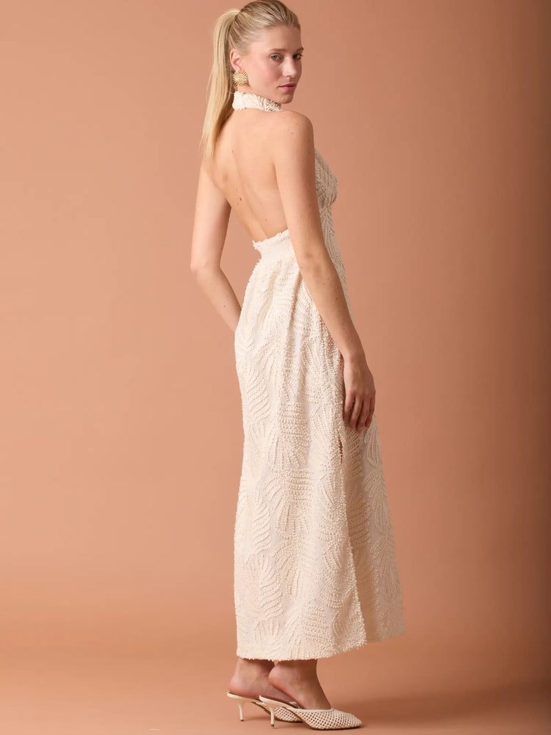 Vestido largo en beige con diseño en relieve, estilo femenino y escote halter.