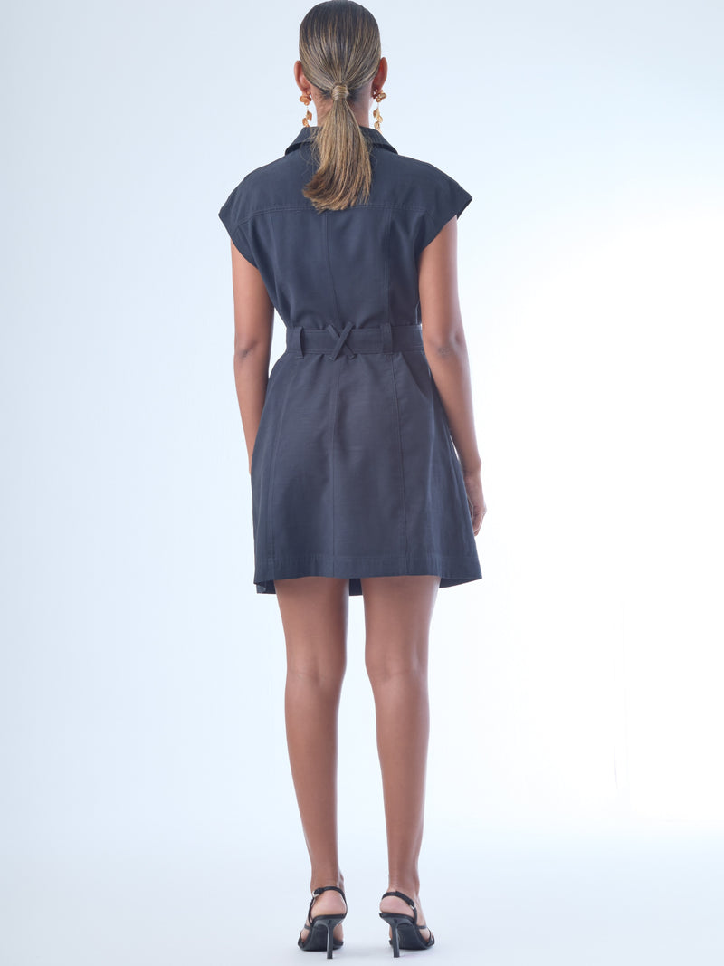 Vestido corto de estilo camisero con botones grandes al frente. Cuenta con cuello clásico, mangas cortas tipo casquillo y bolsillos de parche en el pecho y la parte baja del frente, que aportan un aire utilitario. La cintura se ajusta con un cinturón del mismo tejido, creando una silueta definida. Su diseño combina funcionalidad y sofisticación de manera equilibrada.

Detalles:

Color: Negro