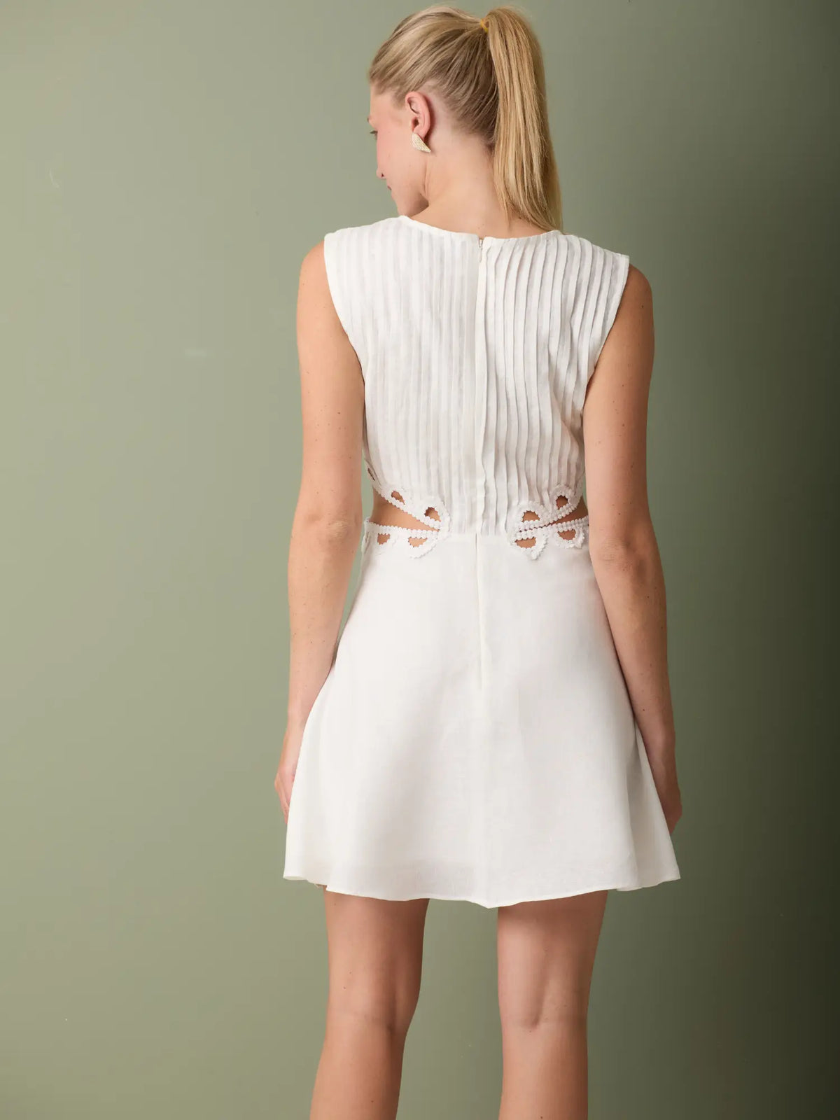 Vestido corto blanco con detalles bordados en los recortes y estilo femenino y sofisticado.
