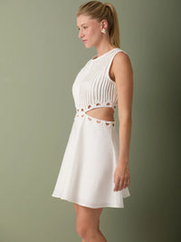 Vestido blanco formal corto con cuerpo plisado y aberturas decorativas que aportan frescura.