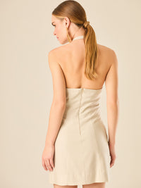 Vestido corto en tono crema de silueta ajustada con escote halter profundo que se adorna con un original detalle de argollas decorativas en el centro del busto, creando un sutil efecto de abertura. Su diseño minimalista con acento sensual lo convierte en una prenda ideal para ocasiones especiales con un toque moderno y sofisticado.

Color: Sand