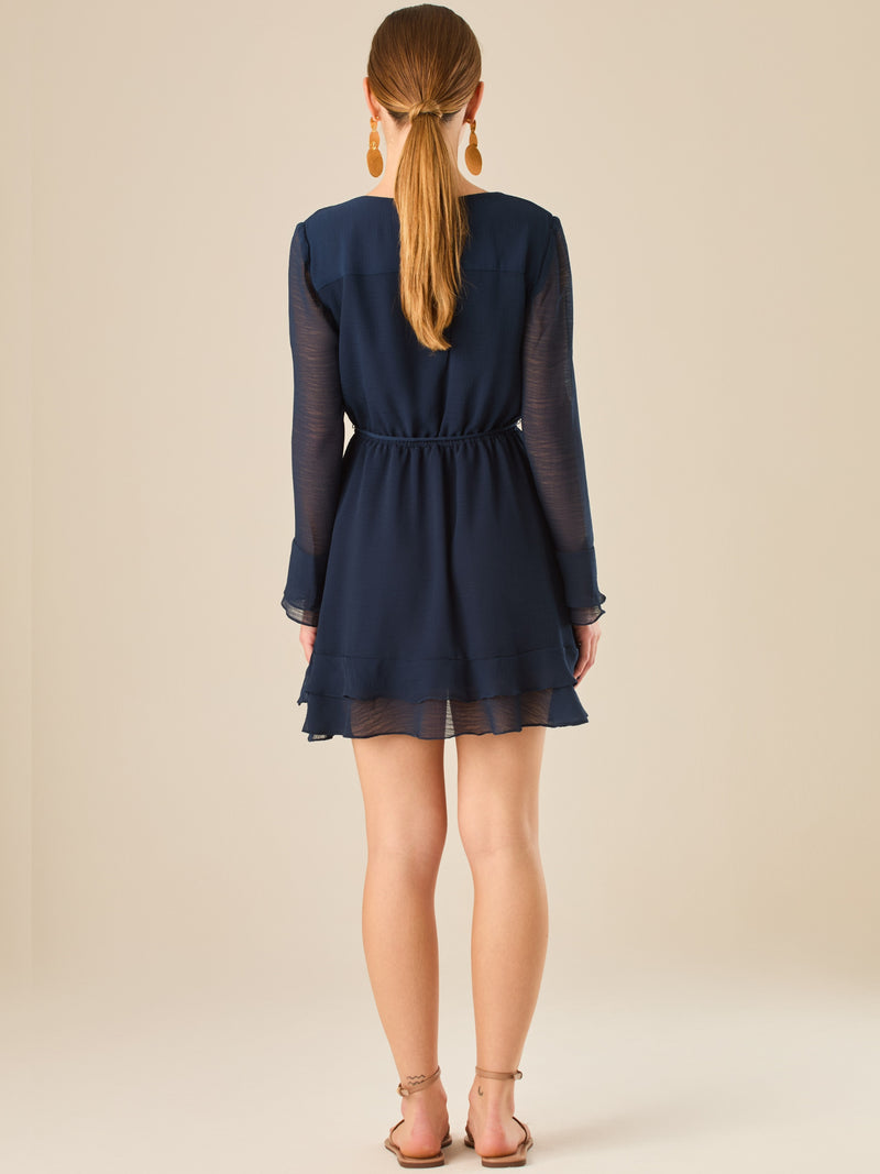 Vestido corto con mangas largas, detalle de volantes y ajuste en la cintura que realza la figura. Su textura ligera y movimiento delicado lo hacen perfecto para un look romántico, femenino y encantador, ideal para ocasiones especiales o salidas con estilo.

Color: Navy

Material: 100% Poliéster

Características: Incluye cinturón a tono.