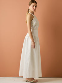 Vestido largo sin mangas con escote halter y cuerpo bordado en delicado encaje. La falda de lino con caída fluida aporta frescura y movimiento, creando una silueta femenina y elegante ideal para ocasiones especiales con un aire natural y sofisticado.