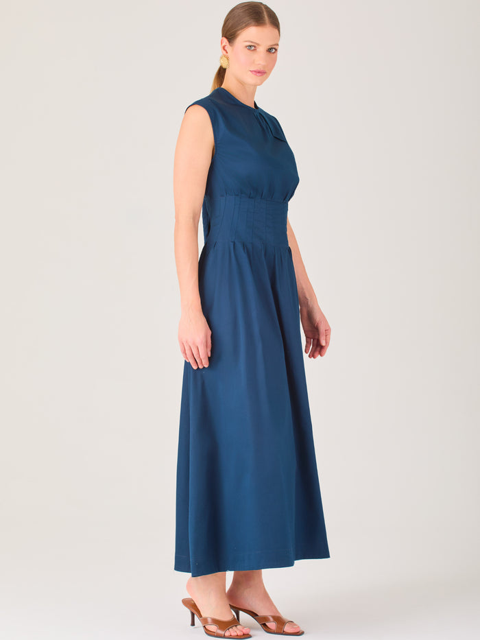 Delicado y femenino, este vestido de largo midi combina una silueta limpia con detalles sutiles. Su diseño sin mangas y escote ligeramente fruncido aporta frescura, mientras que la cintura elástica acentúa la figura con comodidad. Ideal para ocasiones de día, eventos casuales o looks refinados con aire minimalista.