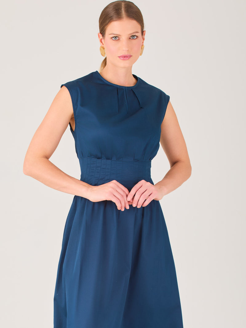 Delicado y femenino, este vestido de largo midi combina una silueta limpia con detalles sutiles. Su diseño sin mangas y escote ligeramente fruncido aporta frescura, mientras que la cintura elástica acentúa la figura con comodidad. Ideal para ocasiones de día, eventos casuales o looks refinados con aire minimalista.