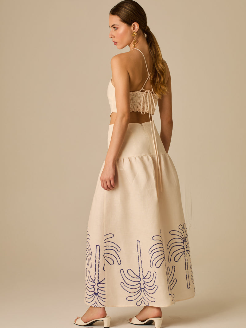 Vestido largo sin mangas con escote recto, aberturas laterales y detalle bordado en el bajo con motivos de inspiración natural. Su diseño limpio y femenino lo convierte en una opción ideal para un look sofisticado con un aire fresco y artesanal.

Detalles:

Color: Sand

Materia: 52% Lino 48% Rayon