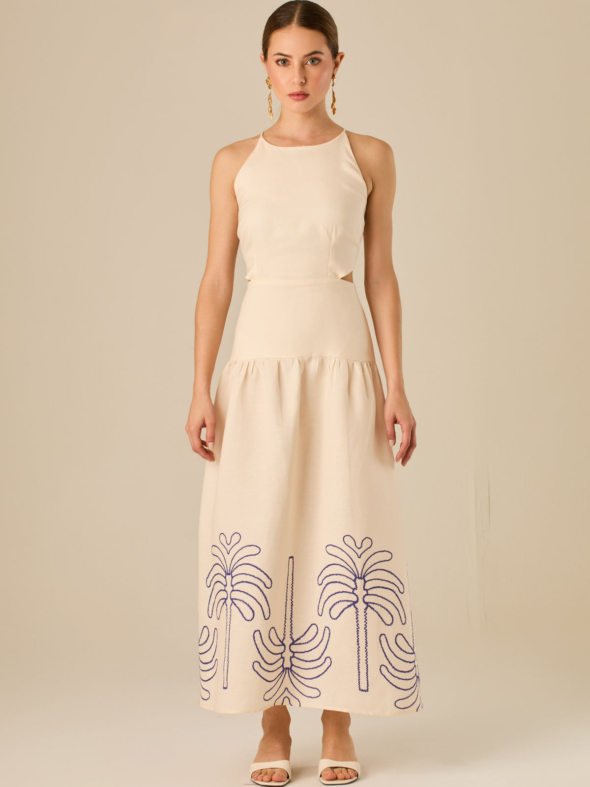 Vestido largo sin mangas con escote recto, aberturas laterales y detalle bordado en el bajo con motivos de inspiración natural. Su diseño limpio y femenino lo convierte en una opción ideal para un look sofisticado con un aire fresco y artesanal.

Detalles:

Color: Sand

Materia: 52% Lino 48% Rayon