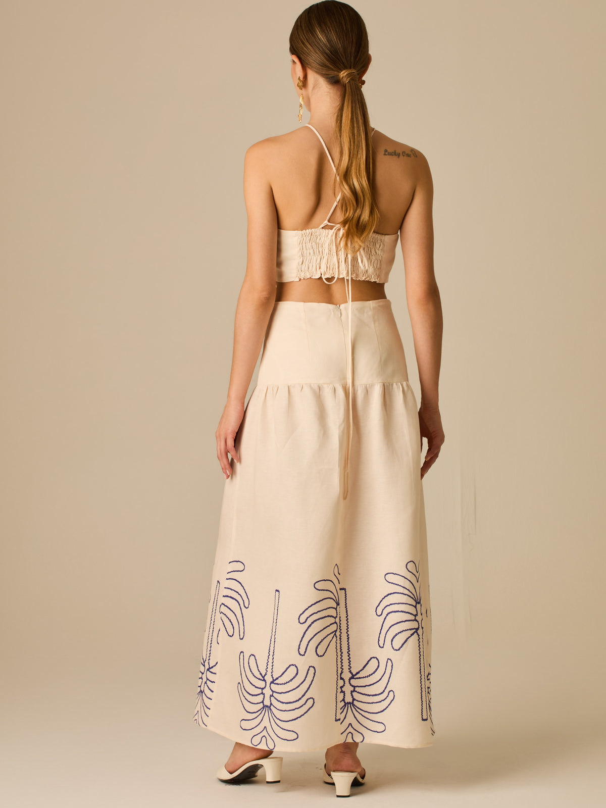 Vestido largo sin mangas con escote recto, aberturas laterales y detalle bordado en el bajo con motivos de inspiración natural. Su diseño limpio y femenino lo convierte en una opción ideal para un look sofisticado con un aire fresco y artesanal.

Detalles:

Color: Sand

Materia: 52% Lino 48% Rayon