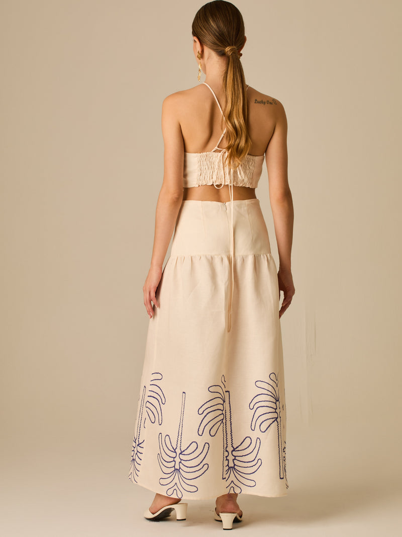 Vestido largo sin mangas con escote recto, aberturas laterales y detalle bordado en el bajo con motivos de inspiración natural. Su diseño limpio y femenino lo convierte en una opción ideal para un look sofisticado con un aire fresco y artesanal.

Detalles:

Color: Sand

Materia: 52% Lino 48% Rayon