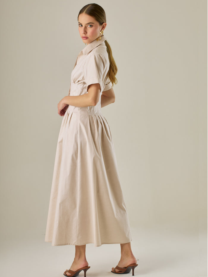 Vestido camisero midi con mangas cortas y falda amplia, ideal para un look elegante y relajado. Su diseño con pinzas en el busto realza la figura con sutileza, mientras que los botones al frente aportan un toque clásico y versátil.

Detalles:

Color: Sand

Material: 97% Algodón 3% Spandex