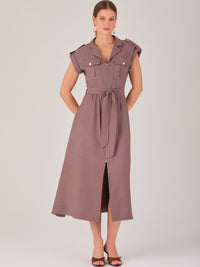 Diseño atemporal con carácter. Este vestido midi sin mangas combina estructura y feminidad con detalles utilitarios como bolsillos frontales, cierre metálico y solapas marcadas. El cinturón en la cintura permite ajustar la silueta, creando un look pulido ideal para la oficina, eventos casuales o estilismos urbanos con elegancia natural.