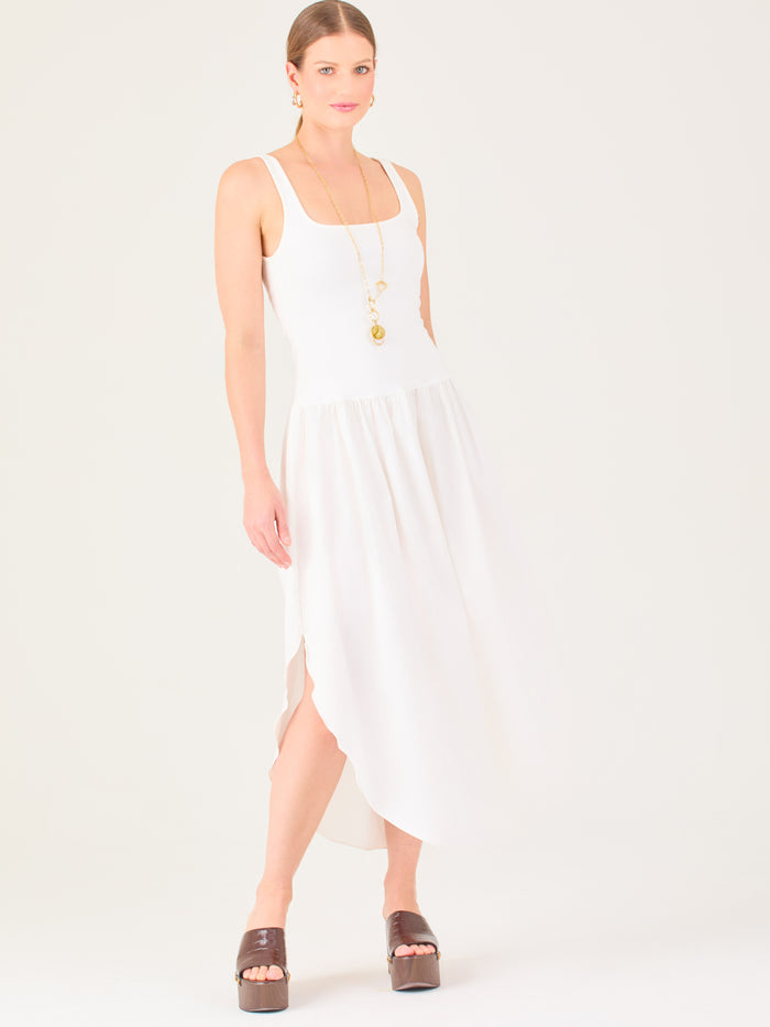 Vestido midi de líneas limpias con tirantes anchos y escote recto. Cuerpo suavemente entallado que cae a una cintura baja fruncida y una falda amplia con bajo redondeado asimétrico tipo pétalo. Una pieza fresca y sofisticada para elevar looks de día o de tarde

Detalles:

Color: Blanco

Material: 95% Poliéster 5% Elastómero 