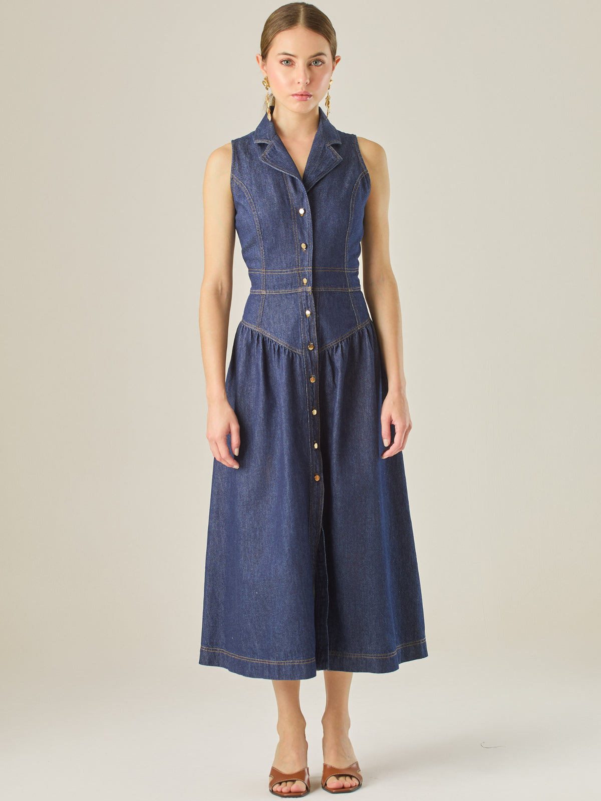 Con una silueta definida y detalles sastre, este vestido midi ofrece un estilo estructurado y femenino. El diseño sin mangas, cuello tipo blazer y costuras marcadas crean un look pulido y contemporáneo. Ideal para días casuales con elegancia o eventos informales donde la comodidad y el estilo se encuentran.