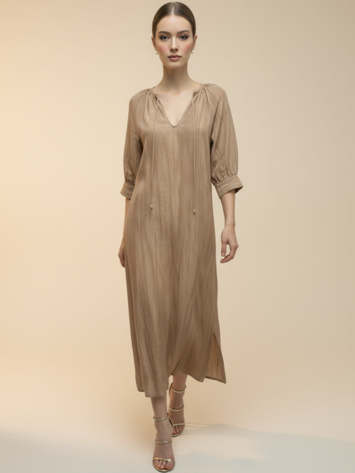 Vestido midi de tejido ligero, cuello en V con cordones y manga 3/4; silueta relajada tipo túnica con caída fluida y textura sutil—elegante y versátil de día a noche