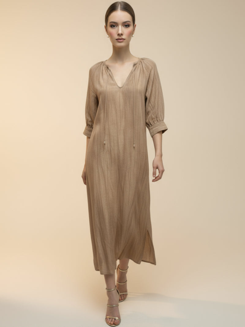 Vestido midi de tejido ligero, cuello en V con cordones y manga 3/4; silueta relajada tipo túnica con caída fluida y textura sutil—elegante y versátil de día a noche