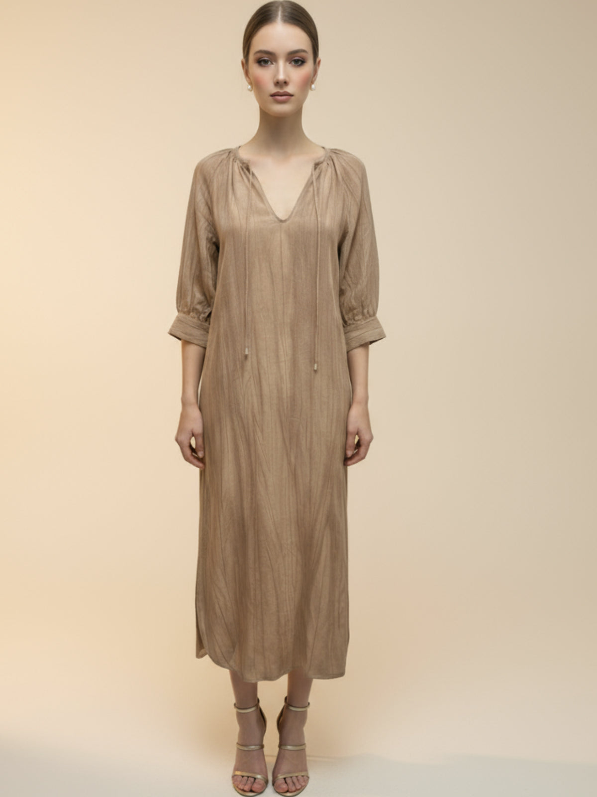 Vestido midi de tejido ligero, cuello en V con cordones y manga 3/4; silueta relajada tipo túnica con caída fluida y textura sutil—elegante y versátil de día a noche