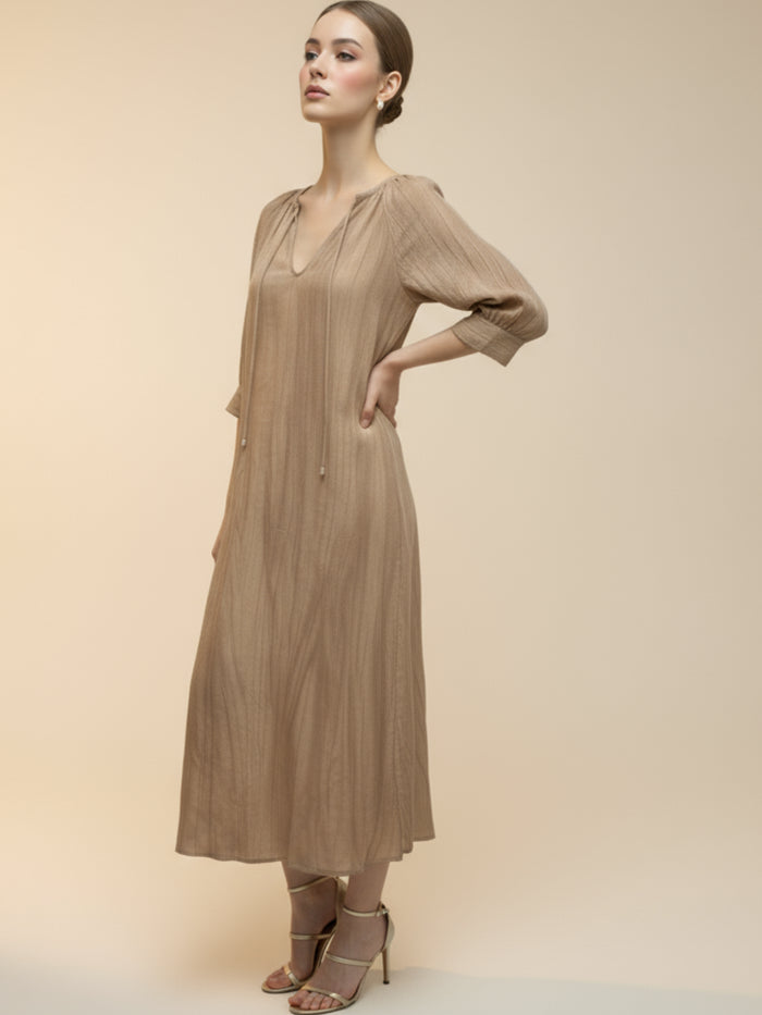 Vestido midi de tejido ligero, cuello en V con cordones y manga 3/4; silueta relajada tipo túnica con caída fluida y textura sutil—elegante y versátil de día a noche