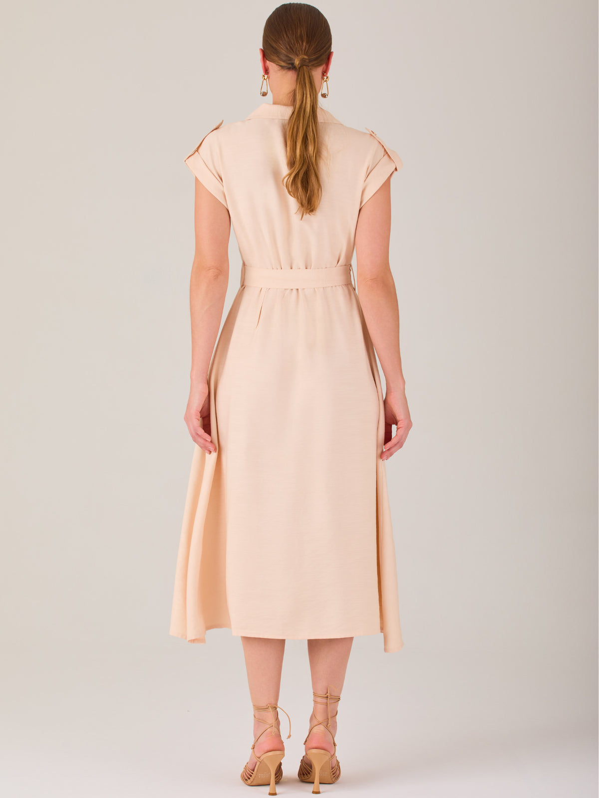 Diseño atemporal con carácter. Este vestido midi sin mangas combina estructura y feminidad con detalles utilitarios como bolsillos frontales, cierre metálico y solapas marcadas. El cinturón en la cintura permite ajustar la silueta, creando un look pulido ideal para la oficina, eventos casuales o estilismos urbanos con elegancia natural.

Detalles: